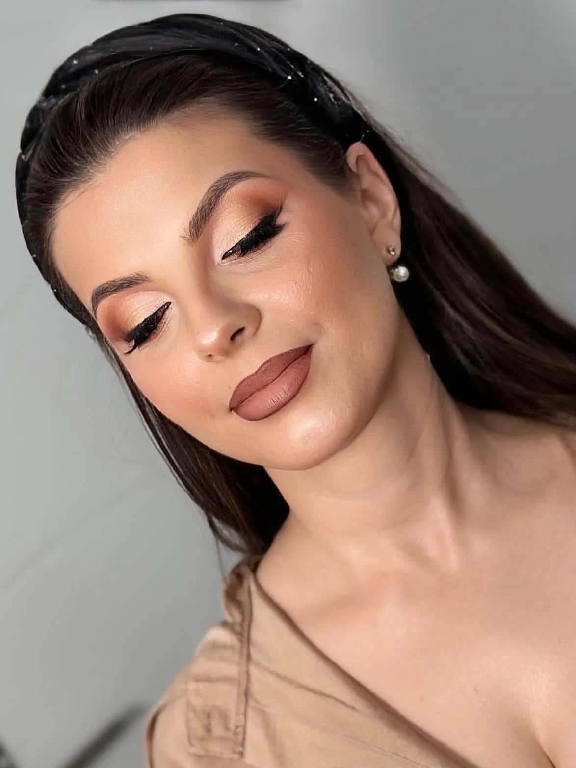 Clientă brunetă cu machiaj în tonuri calde și ochii închiși